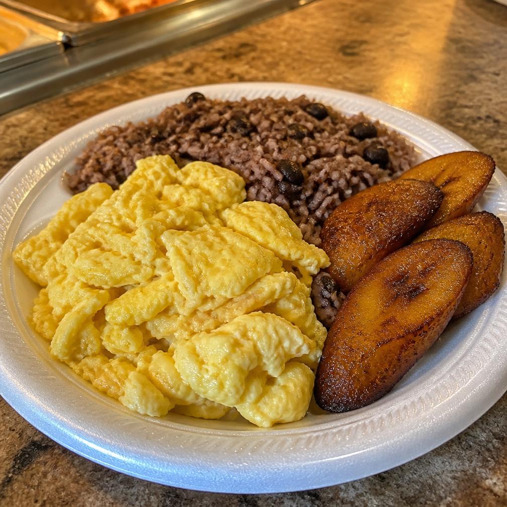 Plato de desayuno con huevos revueltos, arroz con habichuelas y plátanos maduros